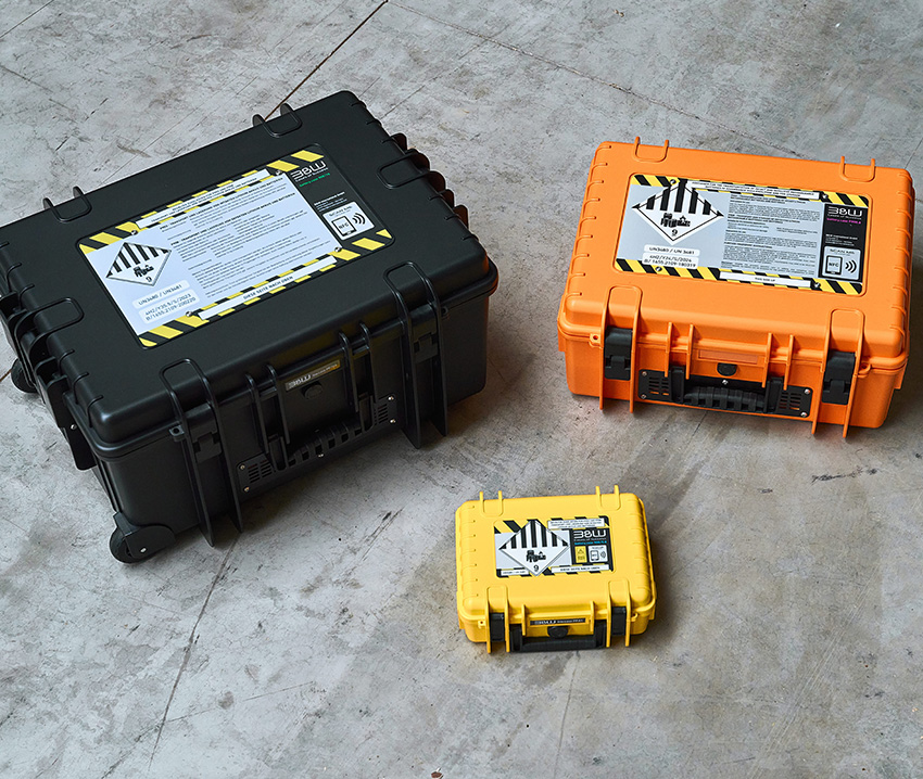 Three different sizes and colors of battery cases lying on the floor and locked.
