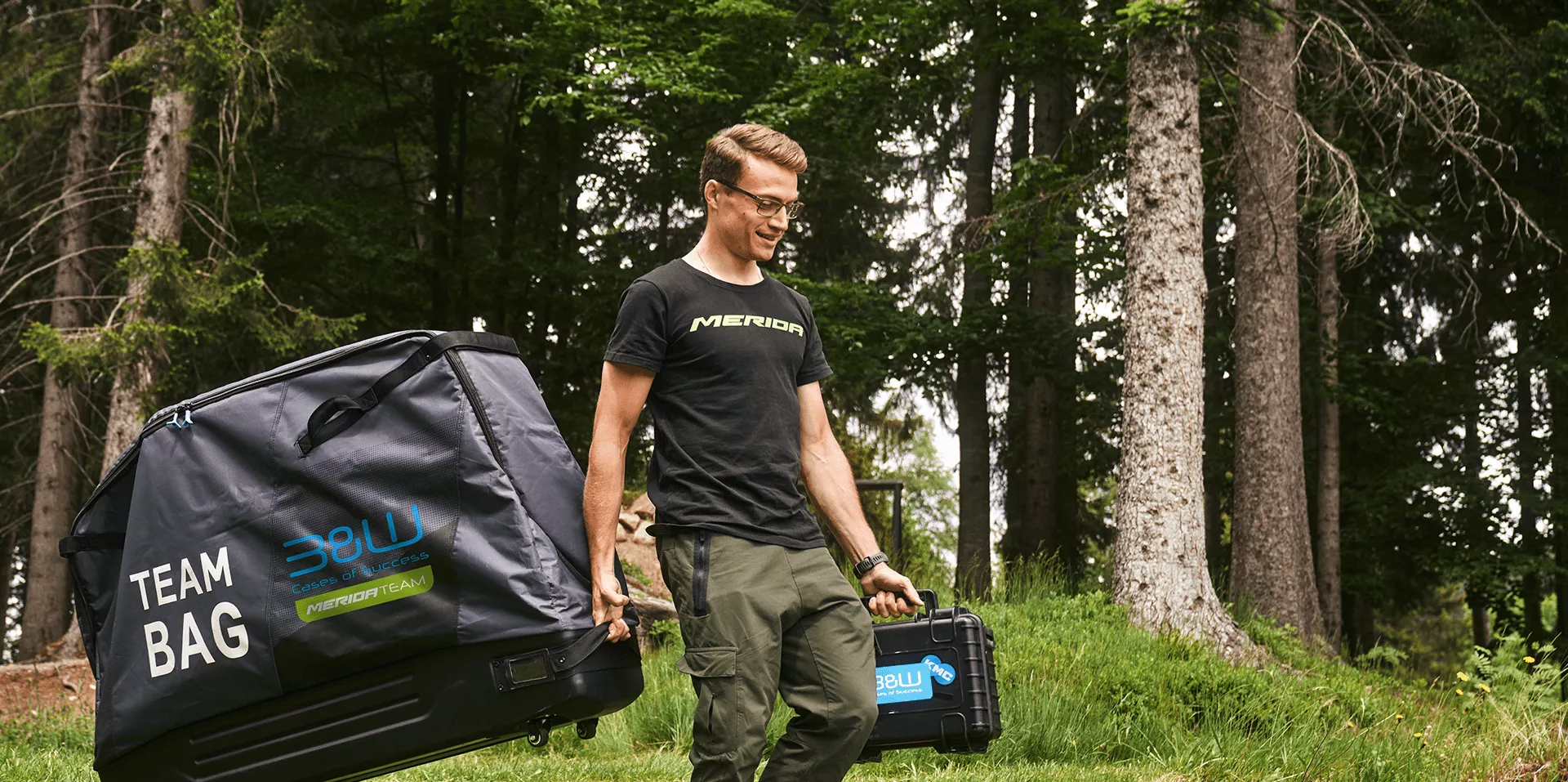 Man pulling a bike case behind him and also carrying a tool case.